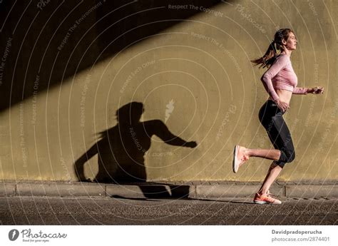 Junge fitte blonde Frau auf der Straße läuft ein lizenzfreies Stock Foto von Photocase