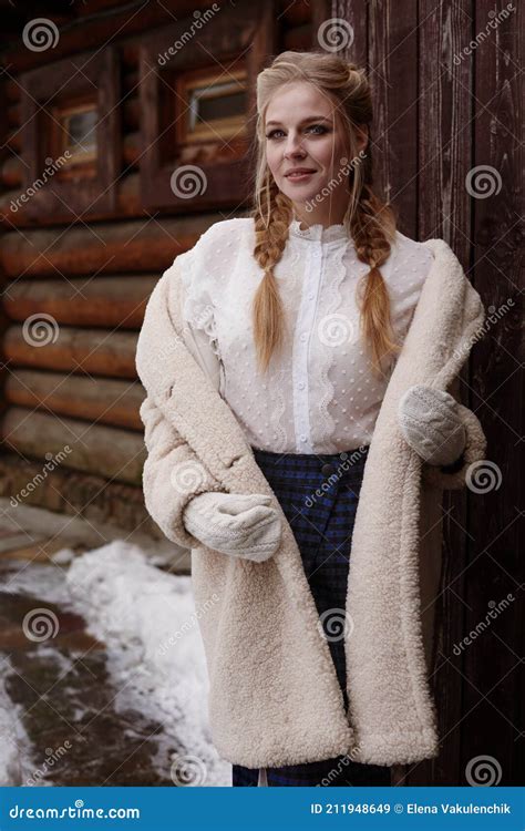 Beautiful Russian Girl Wearing Costume In Russian Style Posing Near Wooden Cottage Stock Image