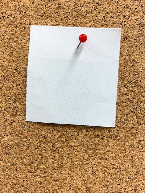 Premium Photo A Sticky Note Hangs On A Pin Board