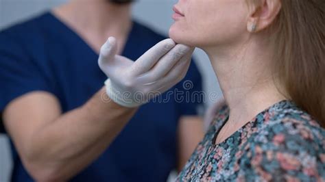 Close Up Doctor Hand Touching Chin Of Unrecognizable Patient In Plastic