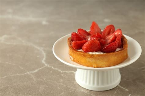 Párese con tarta de fresa en la mesa con textura gris Foto Premium