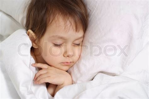 Little girl lying on bed at home | Stock image | Colourbox