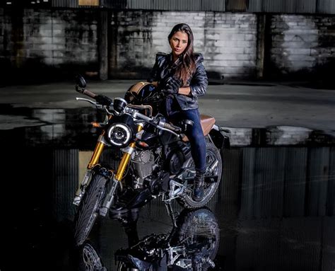 A Woman Sitting On Top Of A Motorcycle