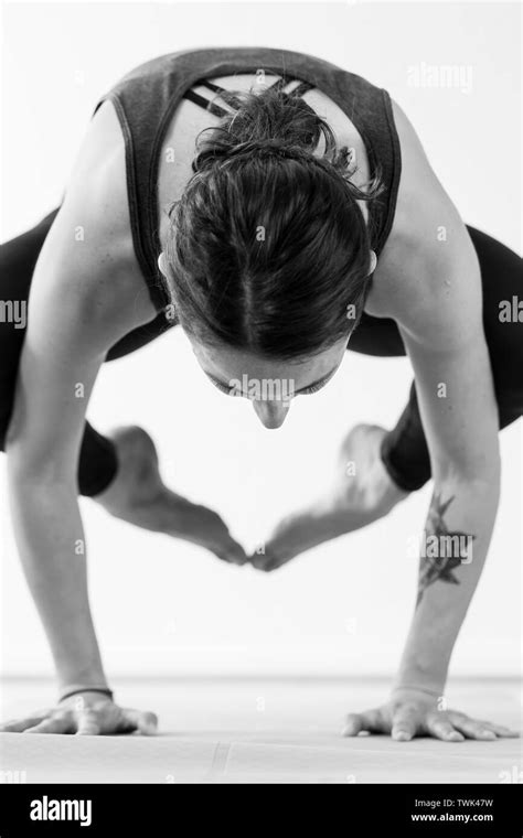 A Brunette Woman In Her 30s Practicing Yoga At Home Concentrated On A Balance Arm Pressing