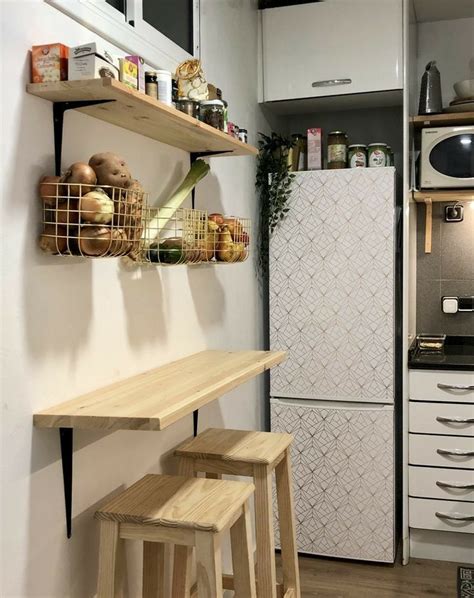 A Kitchen With Two Wooden Stools Next To A White Refrigerator