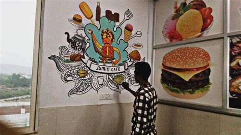 A Man Is Standing In Front Of A Wall With Pictures On It And Hamburgers