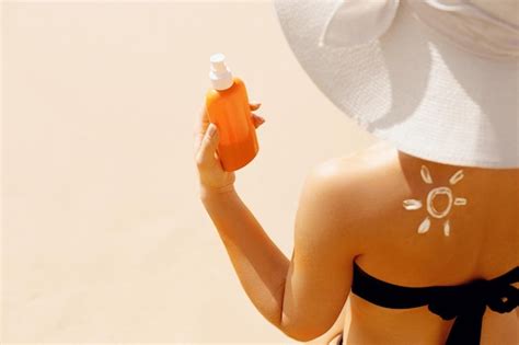 Sexy Jeune Femme En Bikini Tenant Des Bouteilles De Crème Solaire Dans Ses Mains Photo Premium