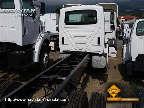 Two White Trucks Parked Next To Each Other