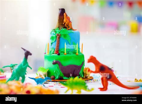 Fiesta De Cumpleaños De Los Niños Pastel De Dinosaurio Tema Niña Soplando Velas Y Abriendo