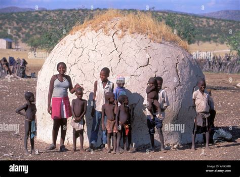 Children Standing Infront Of A Traditional Mud Hut In The Himba Village