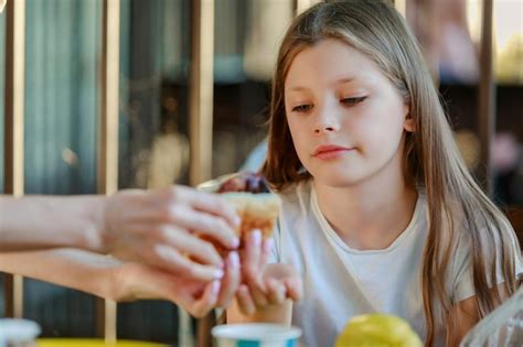 Premium Photo Cropped Hands Giving Food To Girl