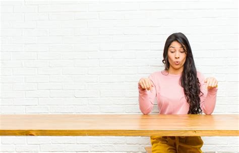 Joven Y Bonita Mujer Latina Con La Boca Abierta Apuntando Hacia Abajo Con Ambas Manos Mirando