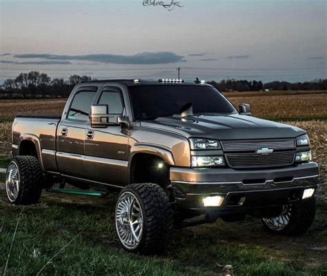 Silver Chevy Duramax Lifted Truck in Field at Dusk