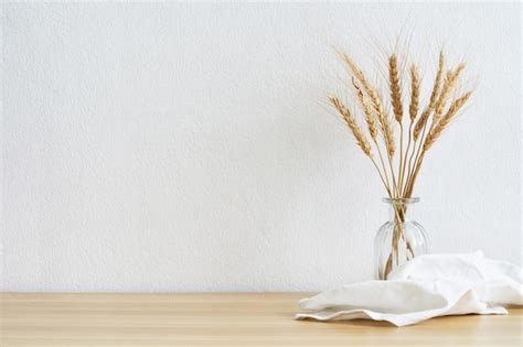 Maqueta en blanco en una pared blanca con trigo de cebada en el jarrón