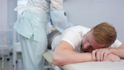 Tracking Shot Of Caucasian Man Lying On Stomach On Medical Couch In