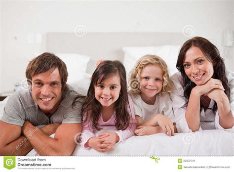 Familia Feliz Que Miente En Una Cama Imagen De Archivo Imagen De