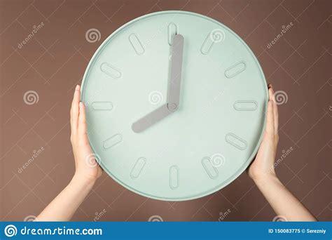 Manos Femeninas Que Sostienen El Reloj En Fondo Del Color Concepto De