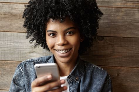 Tir Intérieur De Belle Fille Africaine Heureuse Avec Des Accolades Regardant Et Souriant à La