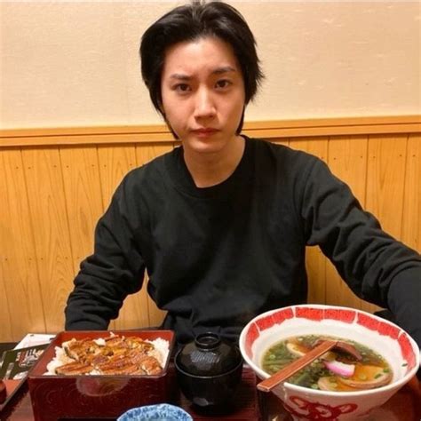 A Man Sitting At A Table With Bowls Of Food And Chopsticks In Front Of Him