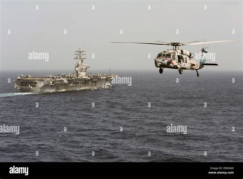 US Navy MH 60R Sea Hawk Helicopters Fly Past The Aircraft Carrier USS