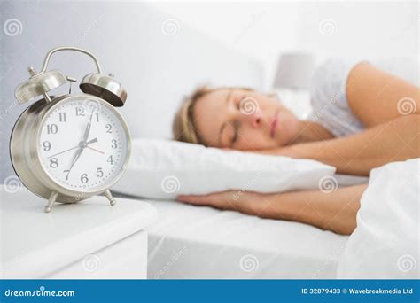 Femme Blonde Endormie Dans Le Lit Tandis Que Son Alarme Montre Le Temps Tôt Image stock Image