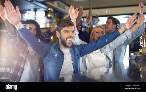 Excited sport fans clapping hands in bar, cheering team, celebrating ...