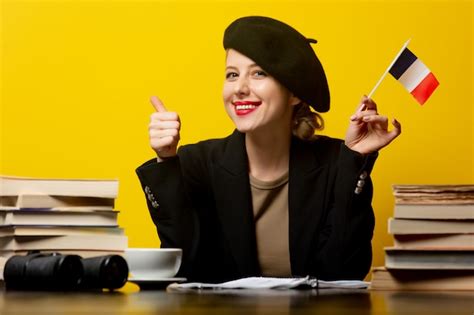 Premium Photo Style Blonde Woman In Beret With French Flag And Books Around On Yellow