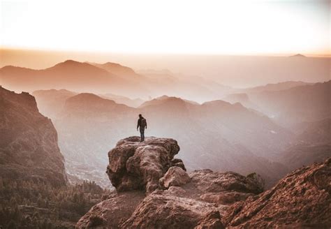 Premium Photo Rear View Of Man Standing On Cliff Against Sky