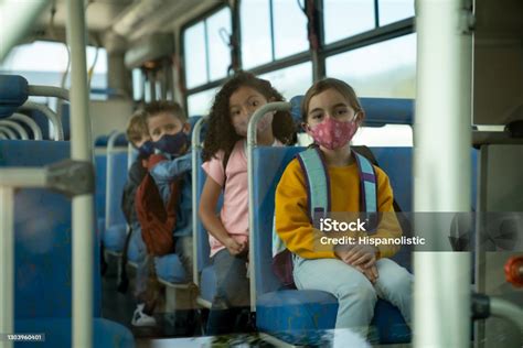 Grupo De Niños Con Máscaras Faciales En Un Autobús Escolar Foto De