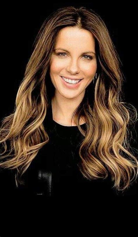 A Smiling Woman With Long Hair And Brown Eyes Wearing Black Shirt