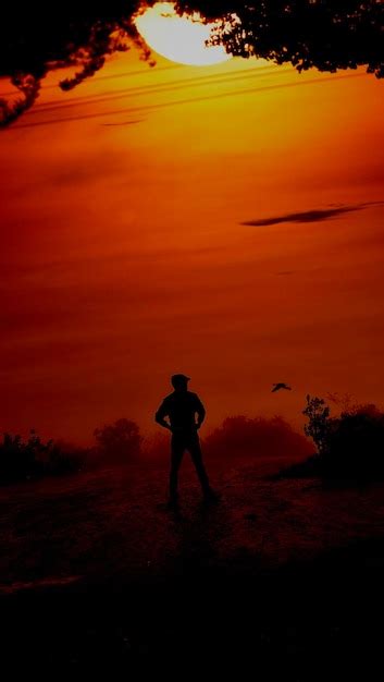 Premium Photo Rear View Of Man Standing Against Sky During Sunset