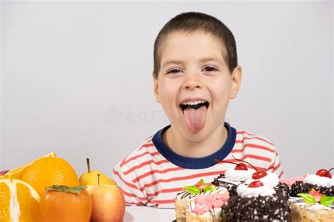 Garoto Bonitinho De Anos Se Senta Diante De Frutas E Bolos E Escolhe