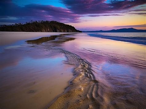 Premium AI Image | A colorful sunset over the ocean with a purple sky ...