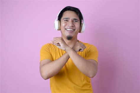 Happy Young Asian Man Listening To Music With Wireless Headphone And