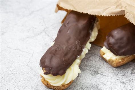 Eclair Au Chocolat Avec Crème Pâtissière Dans Un Sac En Papier