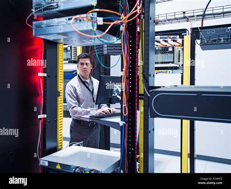 Hispanic Technician Using Computer In Server Room Stock Photo Alamy