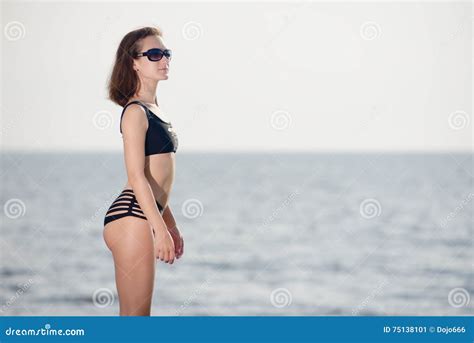 Junges M Dchen Im Schwarzen Bikini Wirft Auf Dem Strand Auf Stockbild