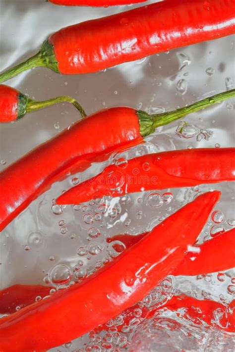 Red Chilli Peppers Close Up In Liquid With Bubbles Slices Of Red