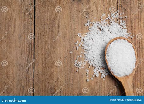 Spoon And Heap Of Natural Sea Salt On Wooden Table Top View Space For