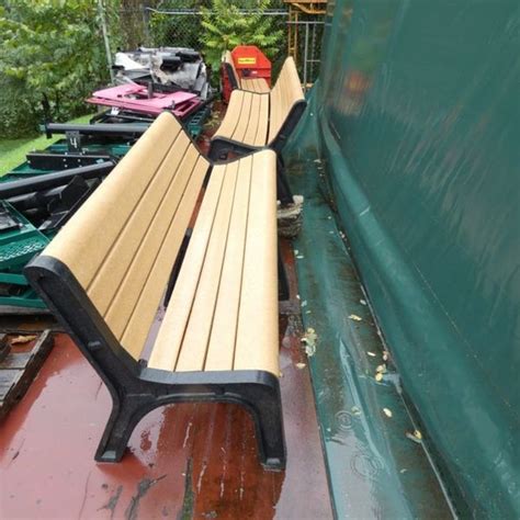 Two Wooden Benches Sitting Next To Each Other On A Wet Ground In Front