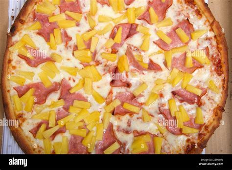 Top View Flat Lay Of One Whole Sliced Hawaiian Pizza In The Box