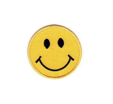 A Yellow Smiley Face Patch With Black Eyes