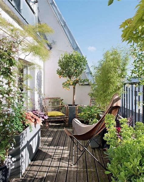 An Outdoor Deck With Potted Plants And Chairs