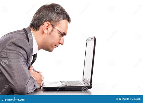 Concentrated Businessman Sitting At Office Desk Working With Lap Stock