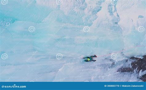 Mountaineer Man Is Leading On Ice Ice Climbing On Frozen Waterfall