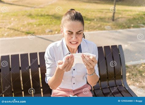 Young Woman Sneezing while Having an Allergy Stock Photo - Image of park, bench: 129554480