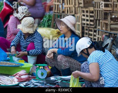 Vietnamese Woman Selling Fresh Fish From The Panniers On A Motorbike In