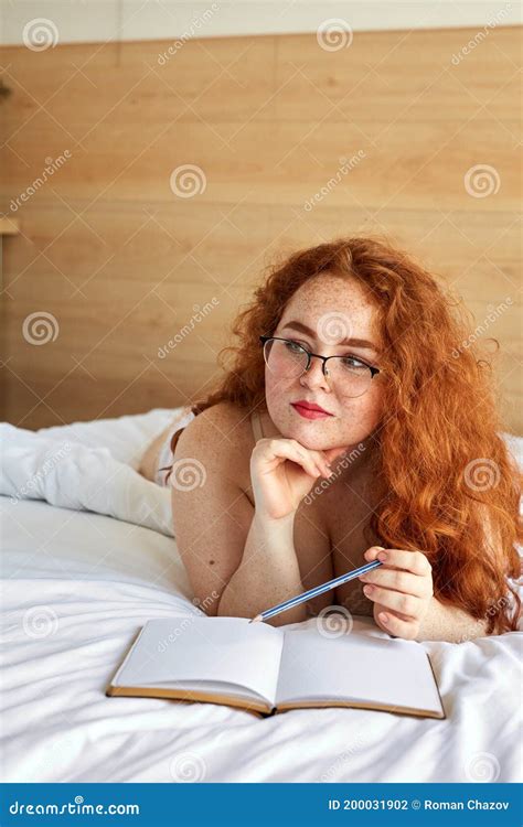 Pretty Half Naked Redhead Woman Make Notes Lying On Bed Stock Photo