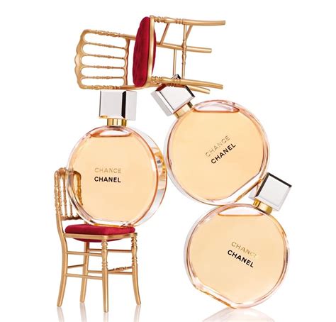 Two Bottles Of Chanel Perfume Sitting On Top Of A Chair Next To Each Other