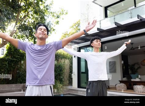 Practicing Outdoor Yoga Male Gay Couple Stretching Arms In Backyard Garden Stock Photo Alamy